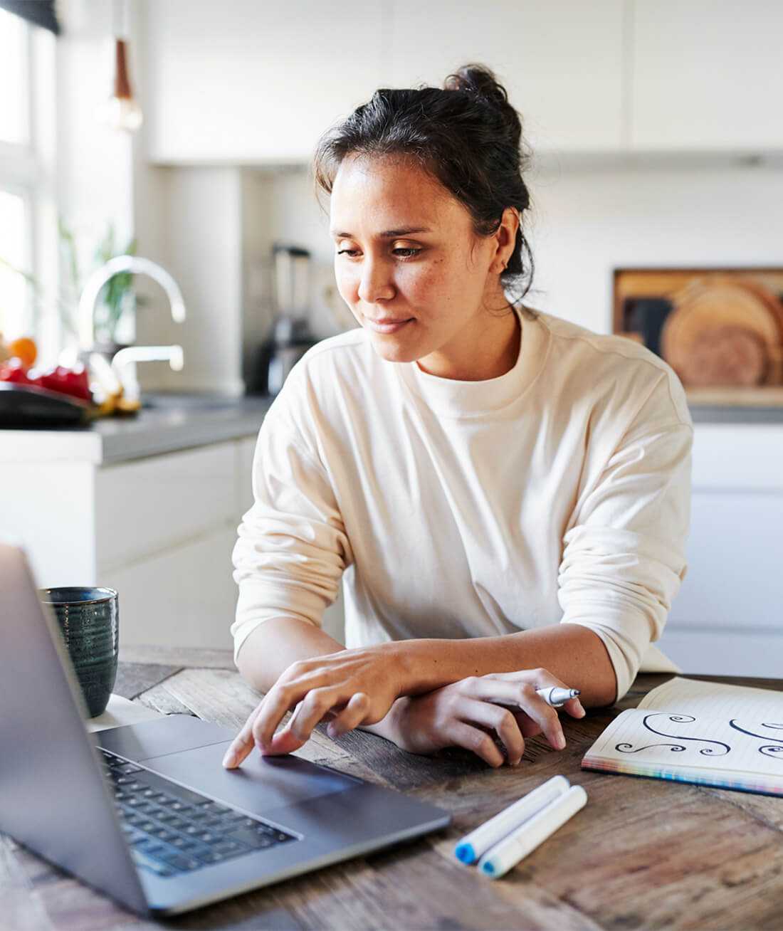 Une femme en train de créer un site internet gratuit chez elle