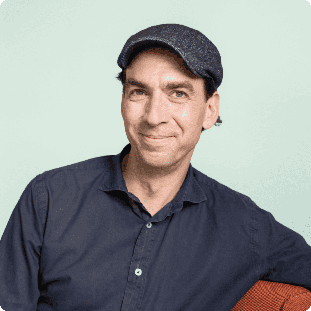 Matthias 'Matze' Henze, CEO and founder of Jimdo wearing a black cap and dark shirt, smiling confidently at the camera, against a light green background.