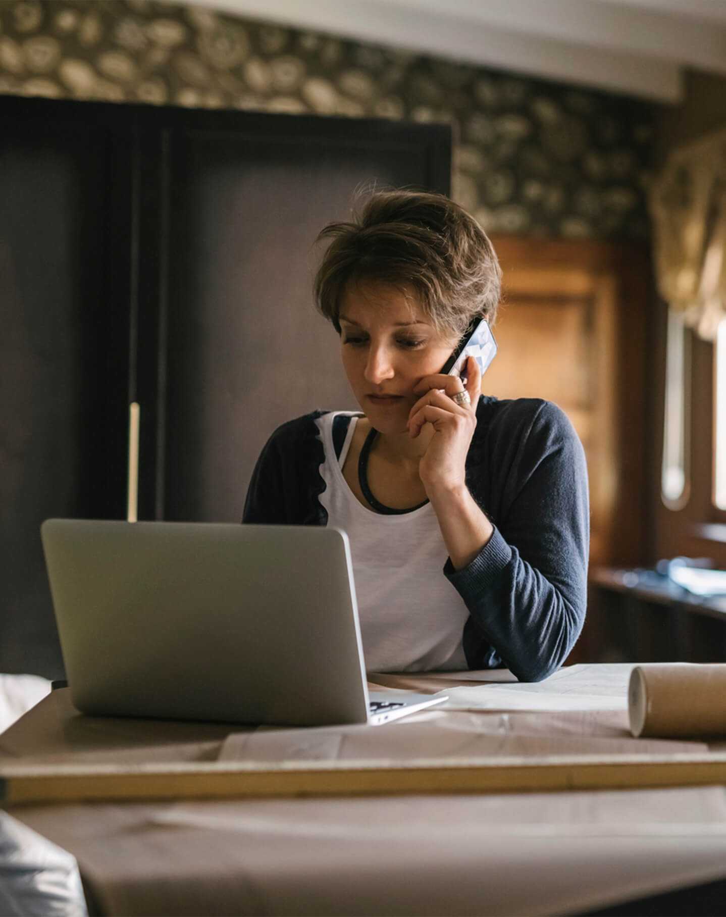 Une femme assise à son bureau qui modifie son site d’architecte