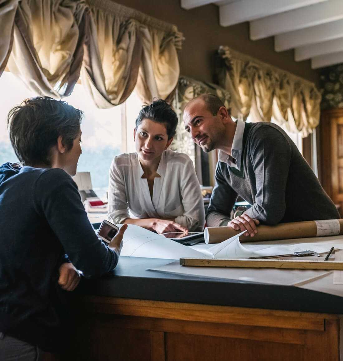 Tre persone lavorano nel loro studio di architettura