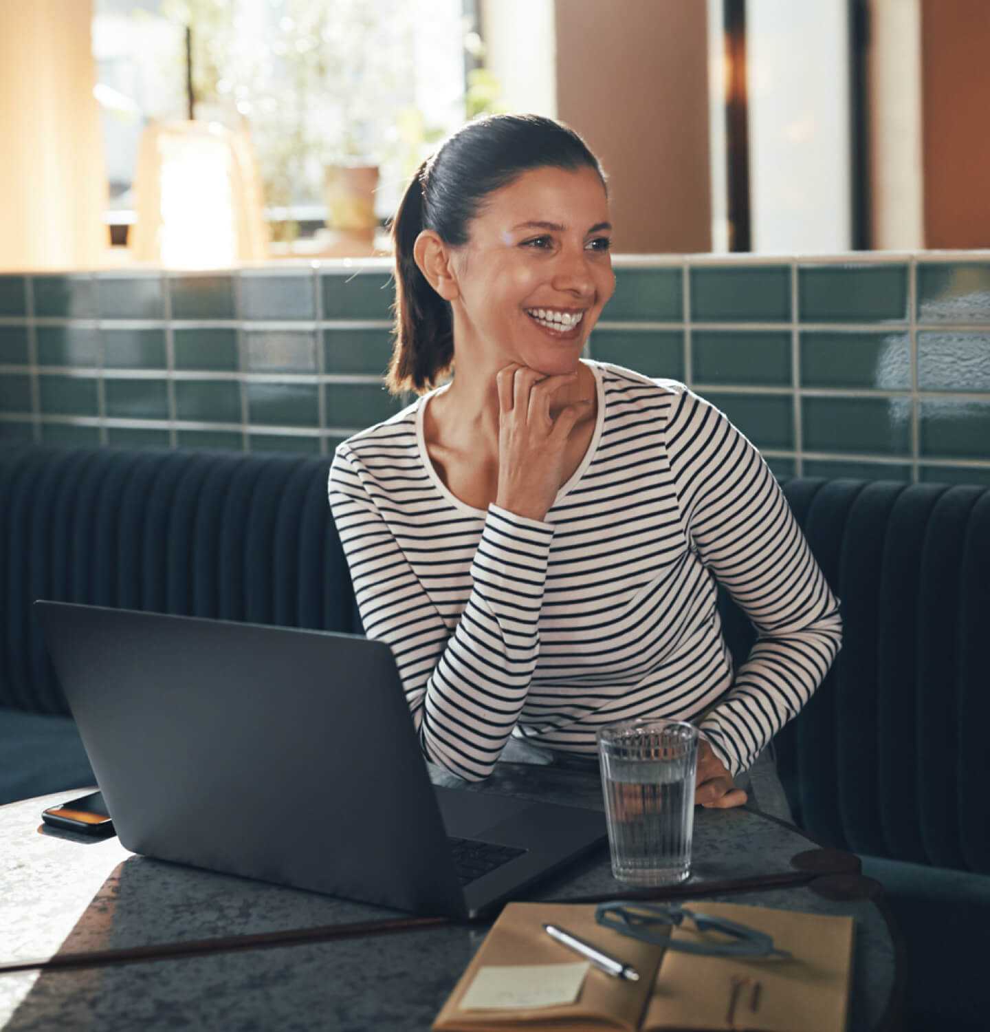 Lachende ondernemer werkt aan website met een kop koffie